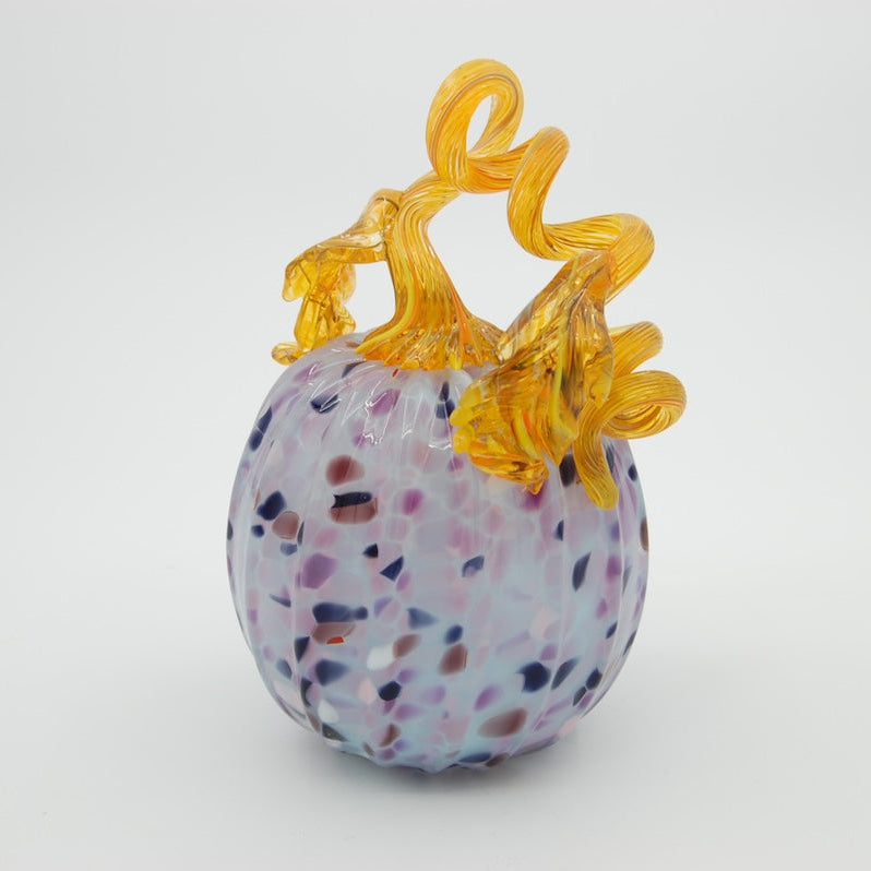 Three colorful glass pumpkins with decorative elements on a white background