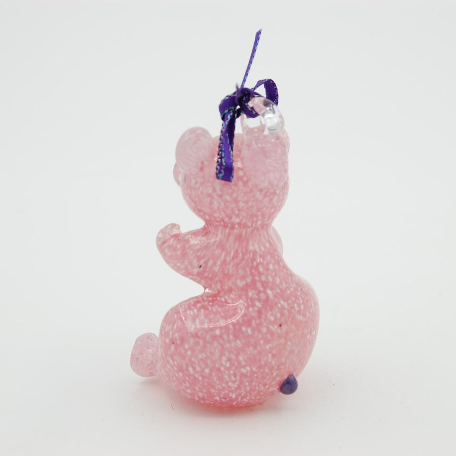 pink blown glass teddy bear ornament with a purple bow on a white background