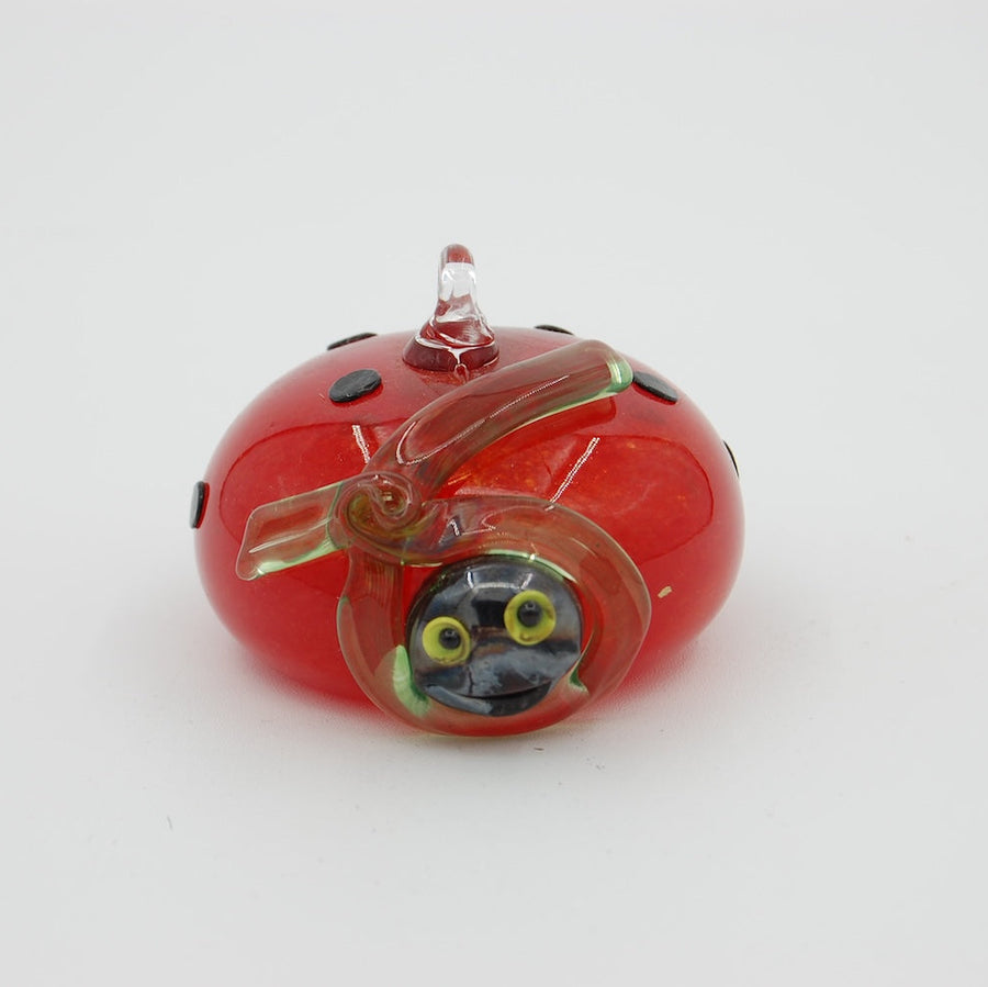 Two glass ladybug ornaments, one blue and one red, on a white background