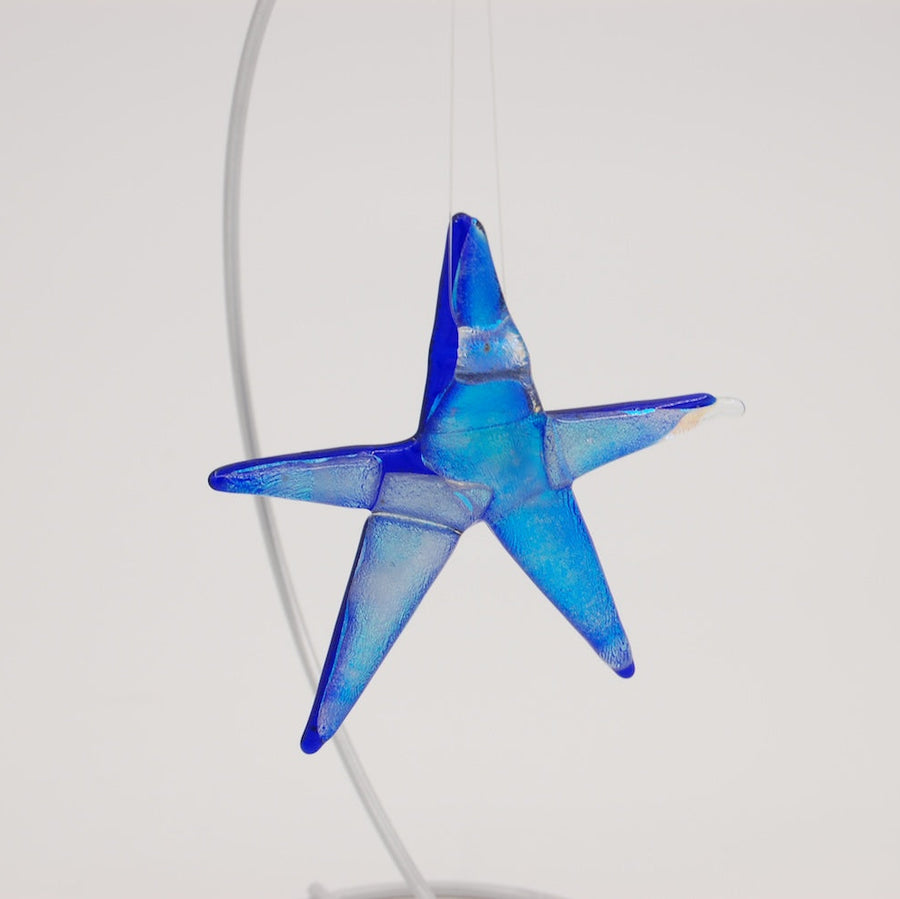Three colorful blown glass star-shaped ornaments on a white background